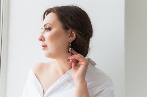 Mujer elegante con aretes. Concepto de accesorios, joyería y bijouterie.