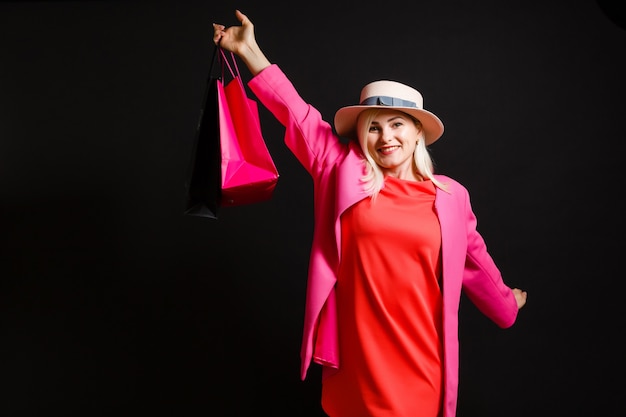 Mujer elegante con bolsas de compras negras, concepto de viernes negro