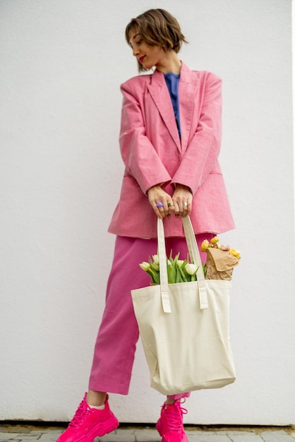 Mujer elegante con bolso de mano en el fondo