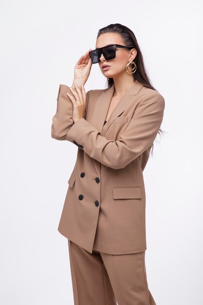 mujer elegante con bonito traje marrón y beige, chaqueta, pantalones de fondo blanco