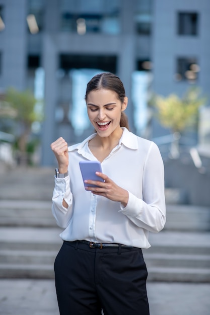 Mujer elegante con una camisa blanca que se siente exitosa