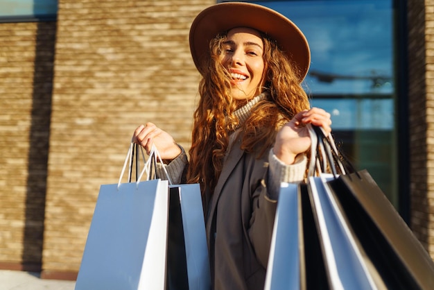 Mujer elegante después de comprar en la calle de la ciudad Compras descuentos de viernes negro concepto de venta