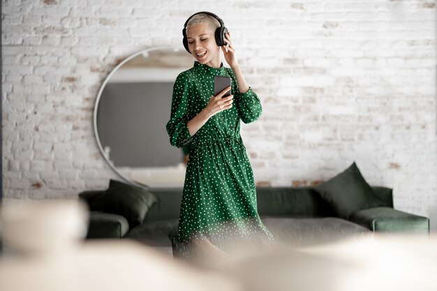 Mujer elegante disfruta de la música en casa