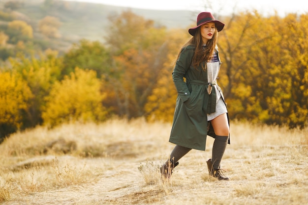 Mujer elegante disfrutando del clima otoñal en la pradera