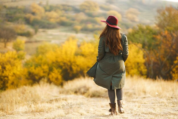 Mujer elegante disfrutando del clima otoñal en la pradera