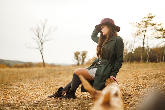 Mujer elegante disfrutando del clima otoñal en la pradera