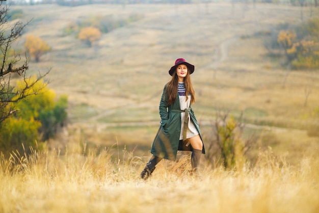 Mujer elegante disfrutando del clima otoñal en la pradera