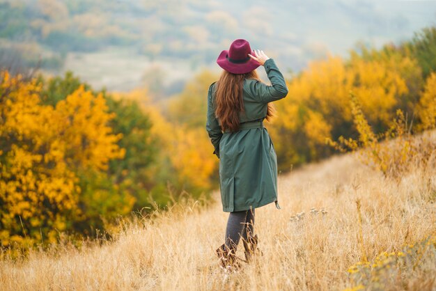 Mujer elegante disfrutando del clima otoñal en la pradera