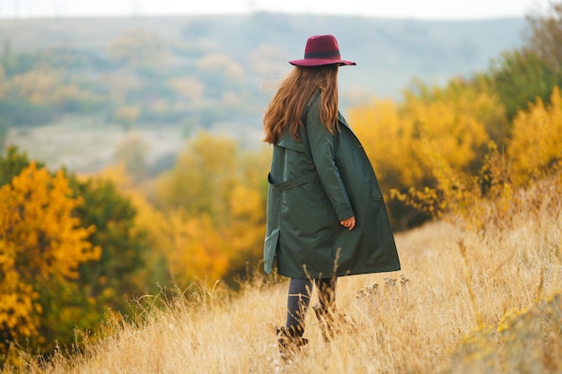 Mujer elegante disfrutando del clima otoñal en la pradera