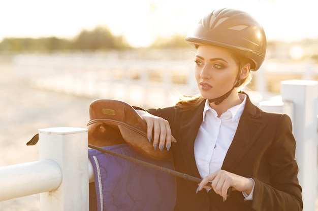 Mujer elegante jinete en casco con látigo