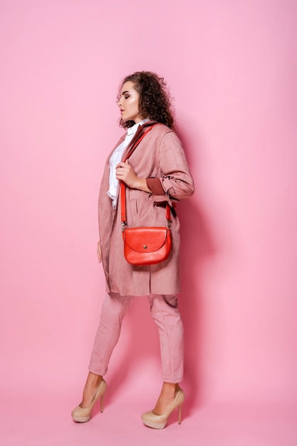 Mujer elegante joven en abrigo rosa de moda