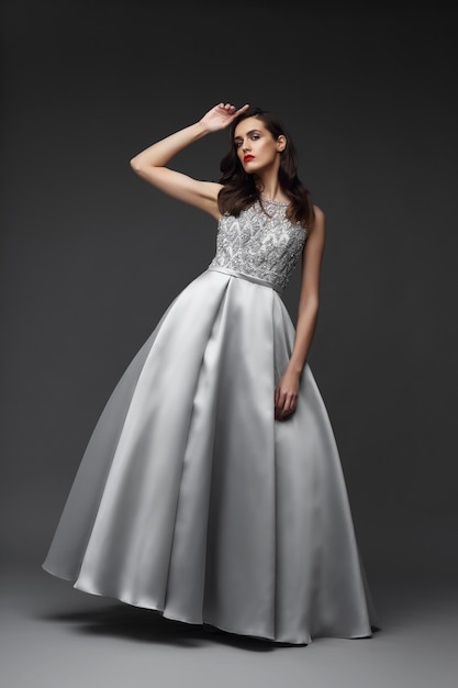 Mujer elegante en vestido plateado. tela elegante, vestido de noche. | Premium