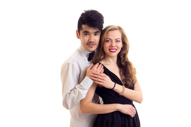 Mujer elegante joven en vestido de noche negro y hombre guapo joven en camisa blanca con corbatín