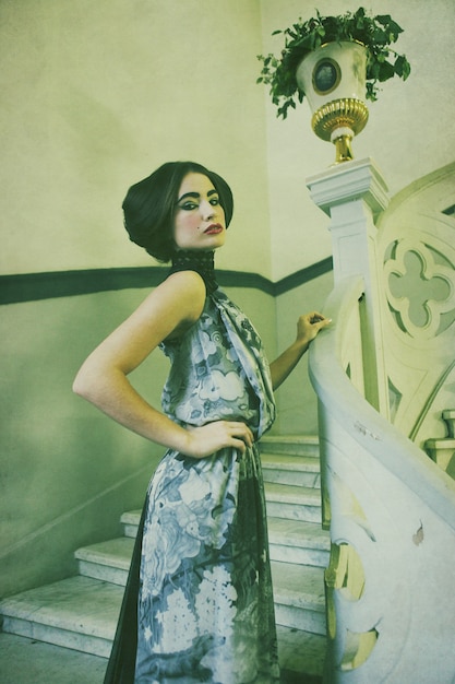 Mujer elegante posando en escaleras vintage.procesamiento vintage.