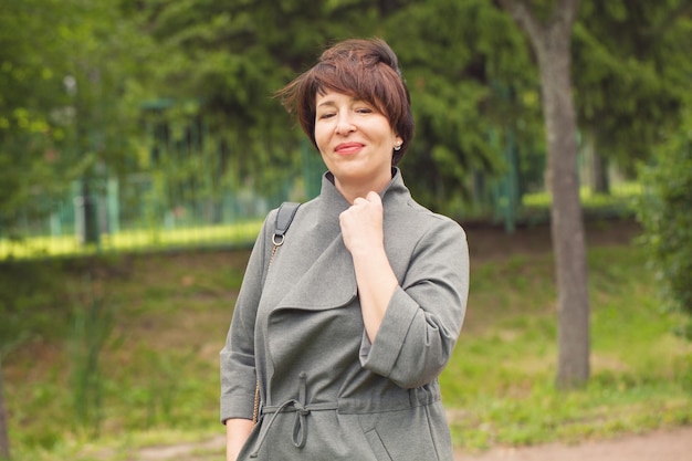 Mujer elegante relajándose al aire libre de 45 años