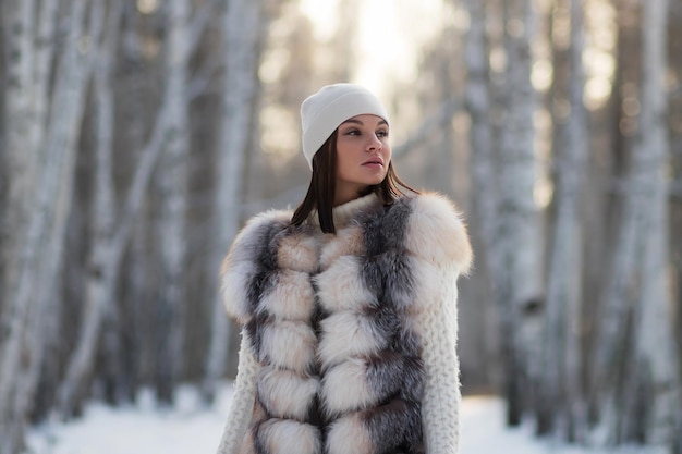 Mujer elegante con ropa de invierno en el bosque