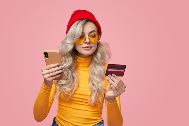 Mujer elegante con smartphone y tarjeta bancaria