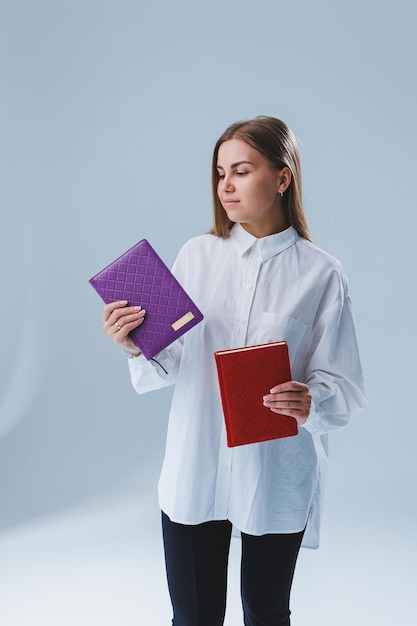 Una mujer elegante sostiene un cuaderno en sus manos Cuaderno para registros comerciales