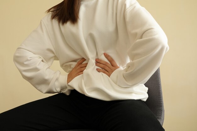 Mujer con elegante sudadera sentada en una silla