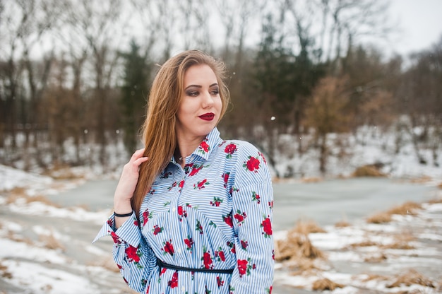 Mujer elegante vestido en día de invierno contra el lago congelado.