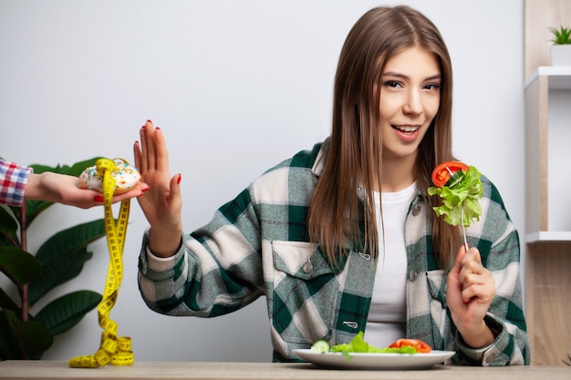 Foto la mujer elige entre alimentos saludables y nocivos.