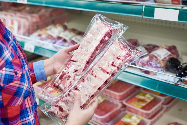 Mujer elige costillas de cerdo en una tienda