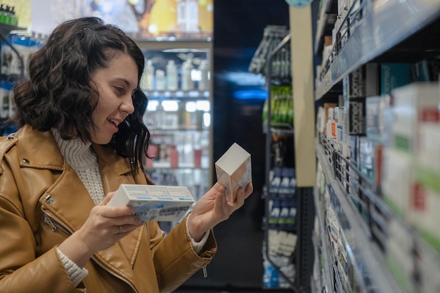 Una mujer elige pasta de dientes en una tienda.