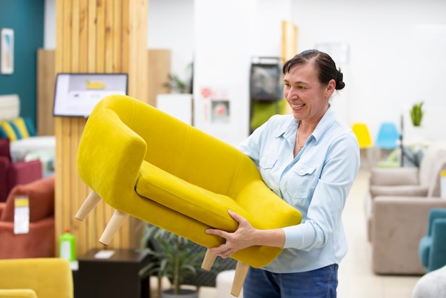 Una mujer elige un sofá en una tienda de muebles El cliente compra muebles