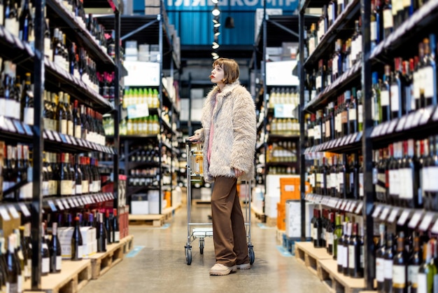 Mujer elige vino en supermercado