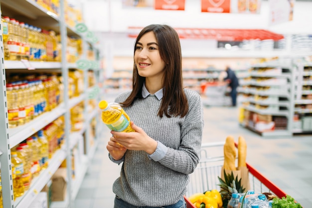 Mujer eligiendo aceite de girasol en un supermercado