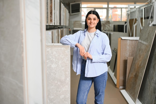 Mujer eligiendo azulejos de baño en el mercado de la construcción