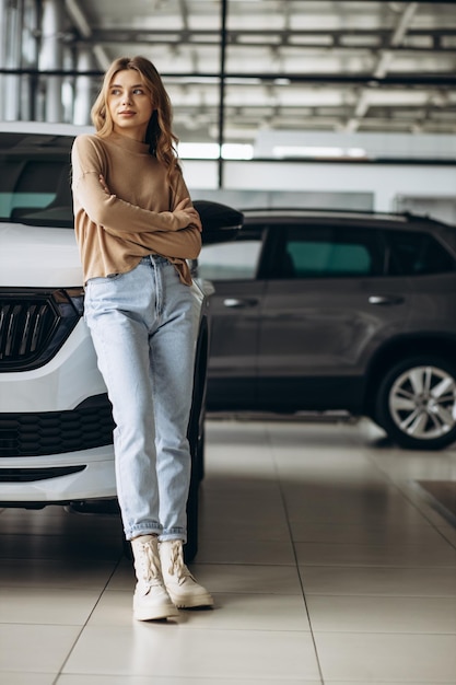 Mujer eligiendo un coche en la sala de exposición de coches