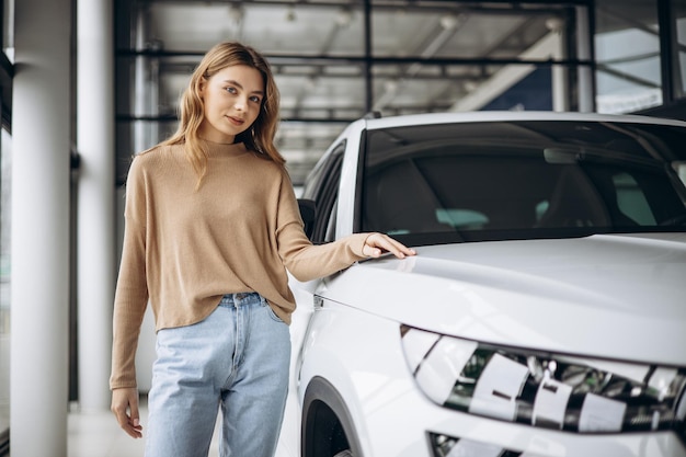 Mujer eligiendo un coche en la sala de exposición de coches