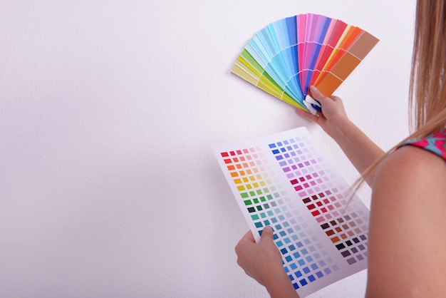 Foto mujer eligiendo el color para la pared de las muestras en la habitación