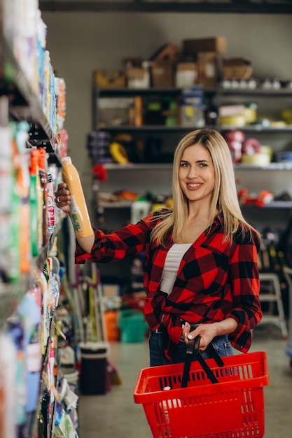 Mujer eligiendo detergente para ropa en el supermercado