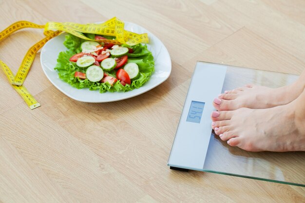 Mujer eligiendo entre hamburguesa chatarra y ensalada fresca