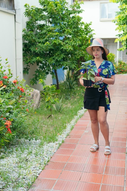 Mujer eligiendo plantas en casa. Concepto de jungla urbana