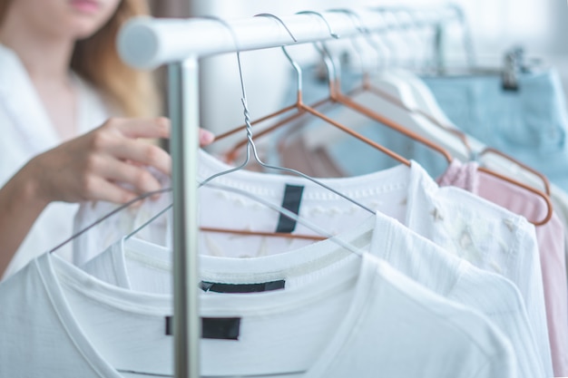 mujer eligiendo ropa en casa vestuario