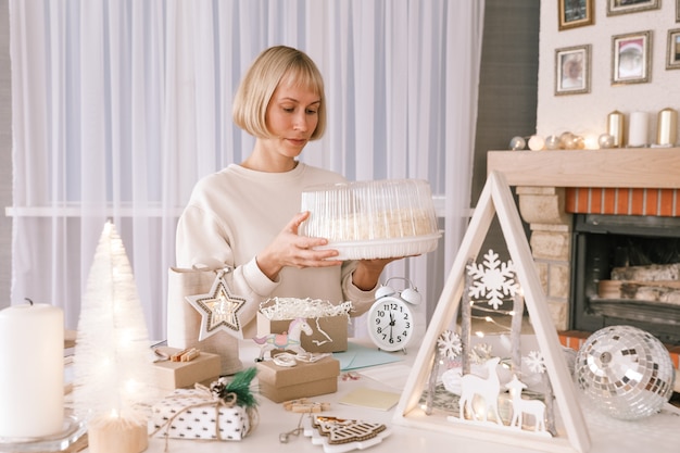 Mujer de embalaje de regalos de Navidad, regalo de embalaje para regalos de Navidad y Año Nuevo. Decoración de cajas de regalo navideñas. Preparándose para la Navidad. Vacaciones de invierno, concepto de decoración del hogar