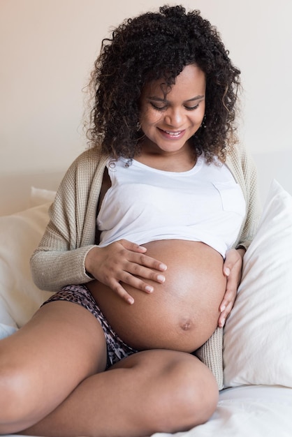 Mujer embarazada africana tocando su vientre de 39 semanas