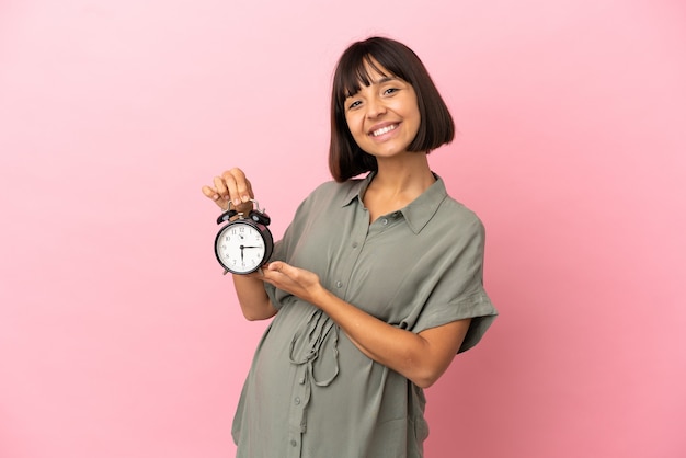 Mujer embarazada con antecedentes aislados y sosteniendo el reloj