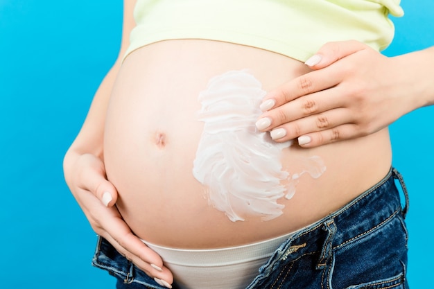 mujer embarazada aplicando crema