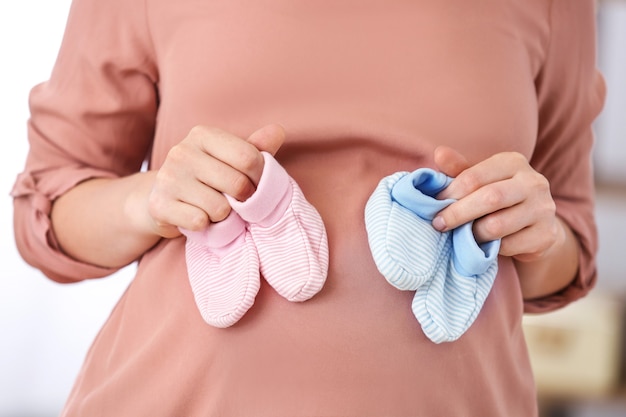 Mujer embarazada, con, bebé, calcetines, en casa, primer plano