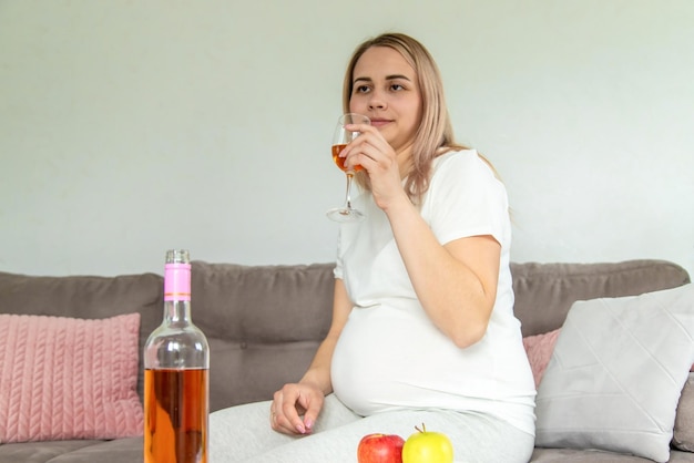Una mujer embarazada bebe vino en un vaso Enfoque selectivo