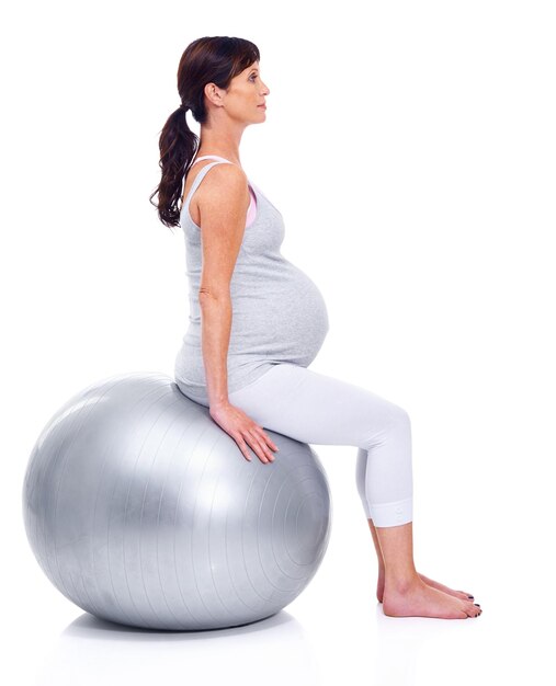Foto mujer embarazada bola y fondo blanco para el bienestar del último trimestre y ejercicio para la maternidad mujer materna entrenamiento y estudio para la salud y el embarazo para mantenerse en forma
