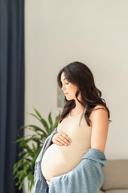 Mujer embarazada bonita en casa