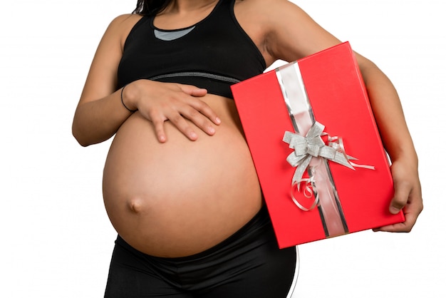 Mujer embarazada con una caja de regalo de Navidad.