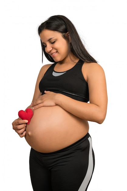 Mujer embarazada con cartel de corazón en el vientre.