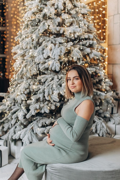mujer embarazada, cerca, árbol de navidad