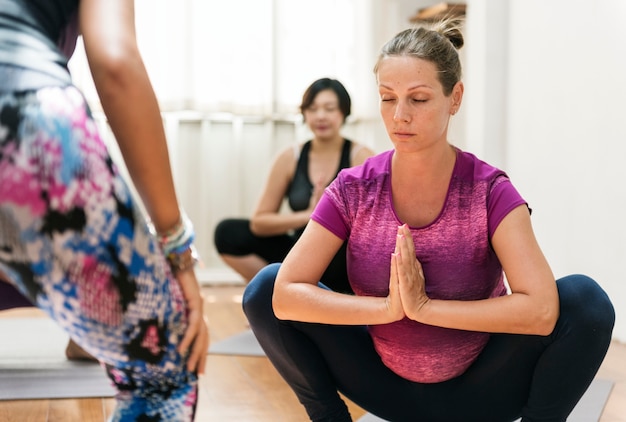 Mujer embarazada en clase de yoga